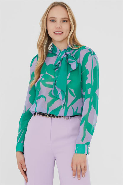 Introducing our stunning cropped blouse, the perfect addition to your summer wardrobe. Featuring a flattering V-neckline and a regular fit, this blouse has long puff sleeves that add a touch of bohemian charm. The leaf pattern in shades of green and turquoise make it a colorful and playful addition to any outfit. Whether you dress it up or down, this blouse is sure to make a statement at any summer occasion. Shop now at Norah Boutique for the perfect bohemian blouse.